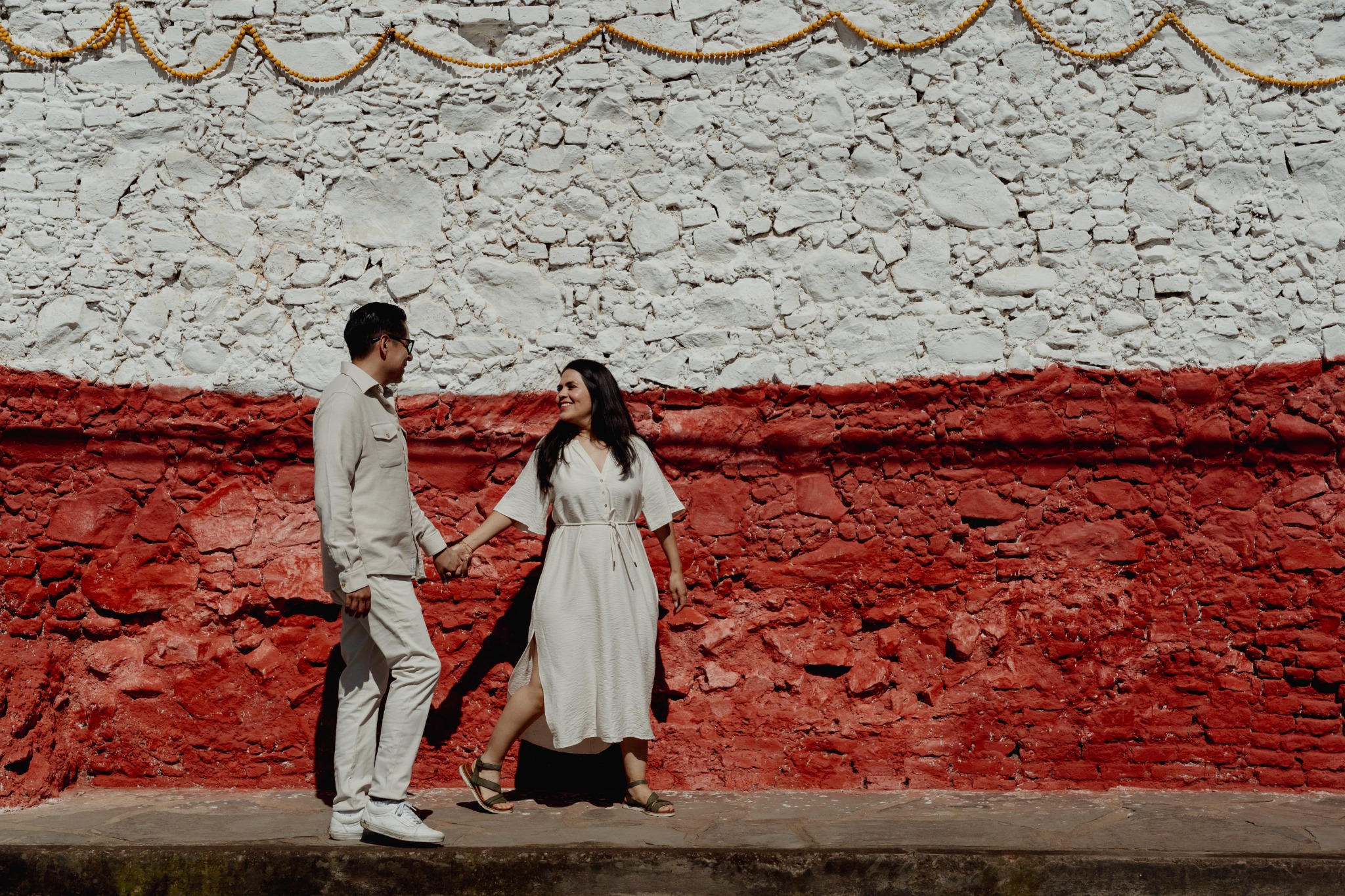 Rosa María y Joacim frente al muro rojo